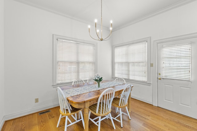 dining space with ornamental molding, light hardwood / wood-style flooring, and a wealth of natural light