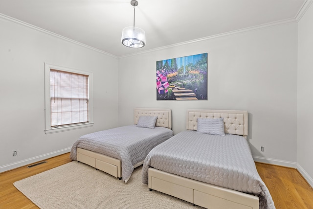 bedroom with ornamental molding and wood-type flooring