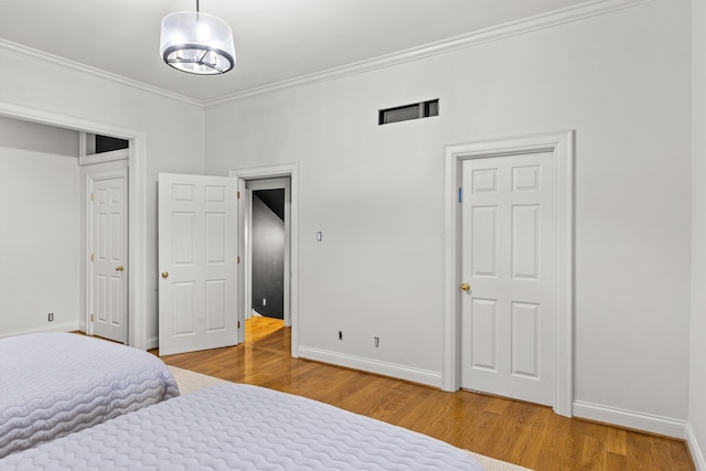 bedroom with hardwood / wood-style floors and ornamental molding