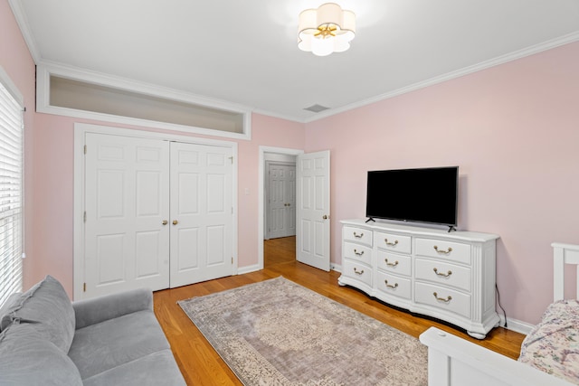 interior space with ornamental molding, a closet, and light wood-type flooring