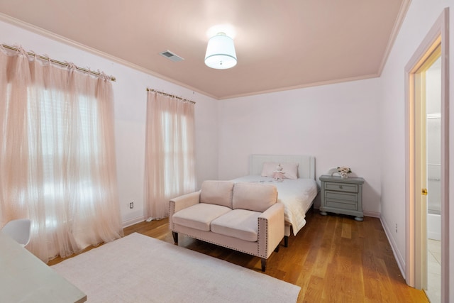 bedroom featuring ornamental molding and light hardwood / wood-style floors