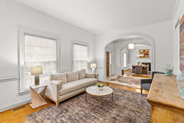 living room featuring wood-type flooring and crown molding