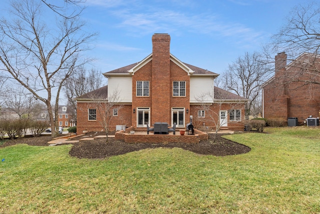 back of property with a yard, a patio, and central air condition unit