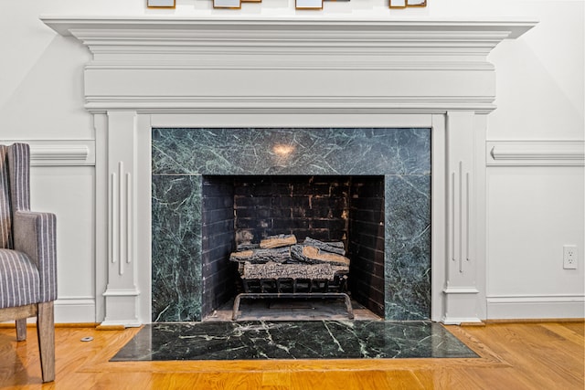 interior details featuring hardwood / wood-style flooring and a high end fireplace