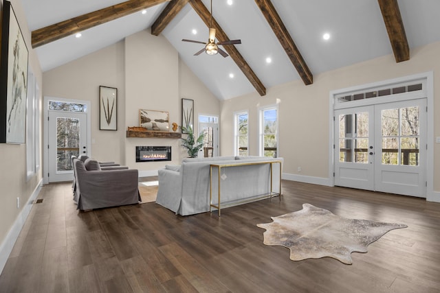 living room with dark wood-type flooring, high vaulted ceiling, french doors, and a healthy amount of sunlight