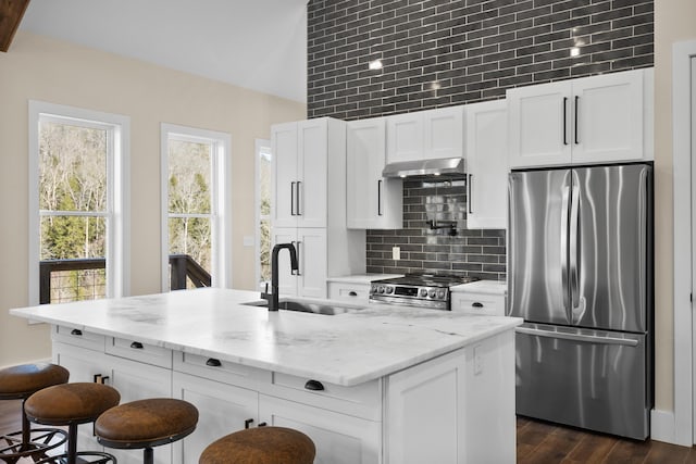 kitchen with appliances with stainless steel finishes, sink, a center island with sink, and white cabinets