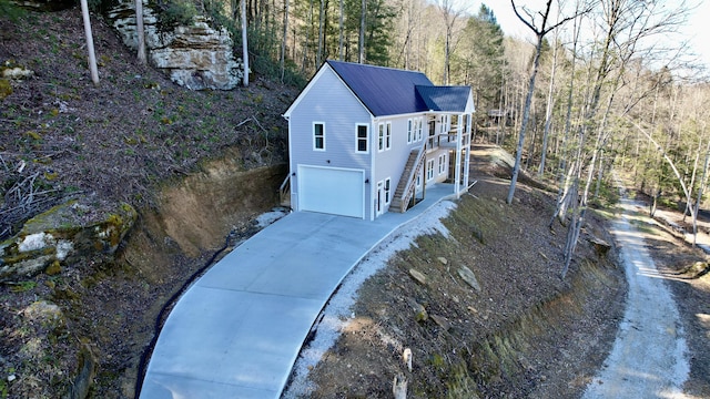 780 Lake Rd, London, KY 40741 - view of side of property with a garage, concrete driveway, and a forest view