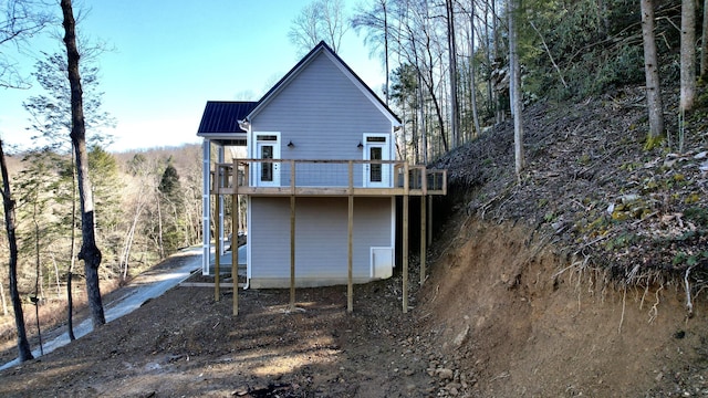 rear view of house featuring a wooden deck