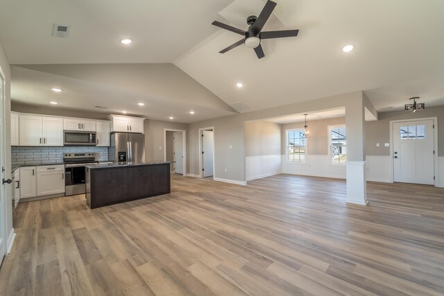 interior details with dark stone countertops, sink, decorative backsplash, and white cabinets