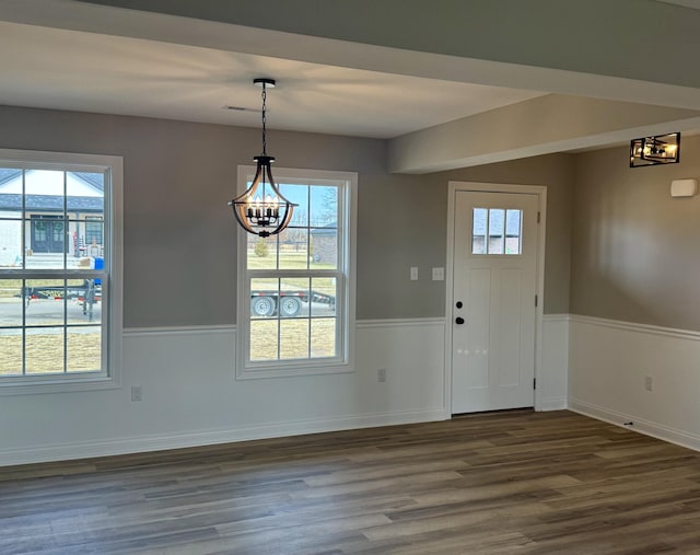 foyer entrance featuring dark wood-type flooring and a notable chandelier