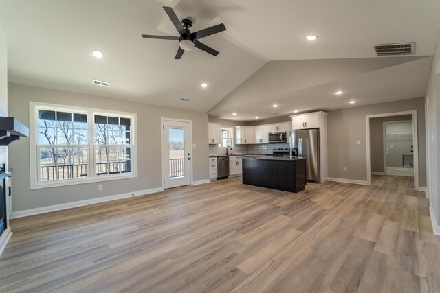 kitchen featuring a kitchen island, white cabinetry, appliances with stainless steel finishes, and sink