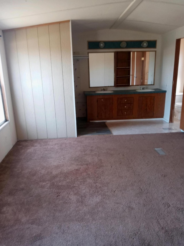 interior space featuring lofted ceiling with beams, carpet, and a sink