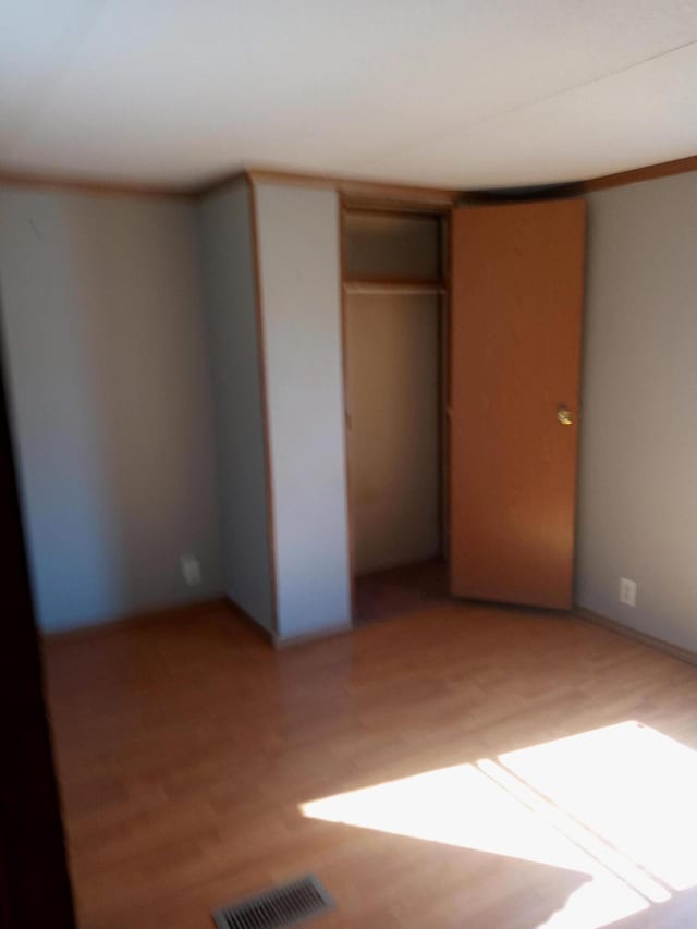 unfurnished bedroom featuring visible vents and light wood-type flooring