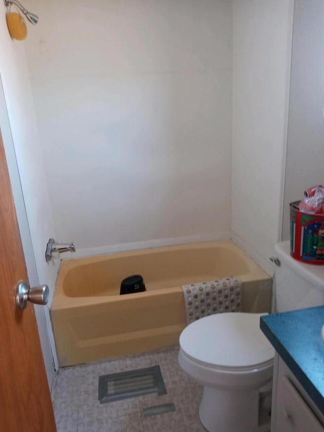 bathroom featuring toilet, a bath, and vanity