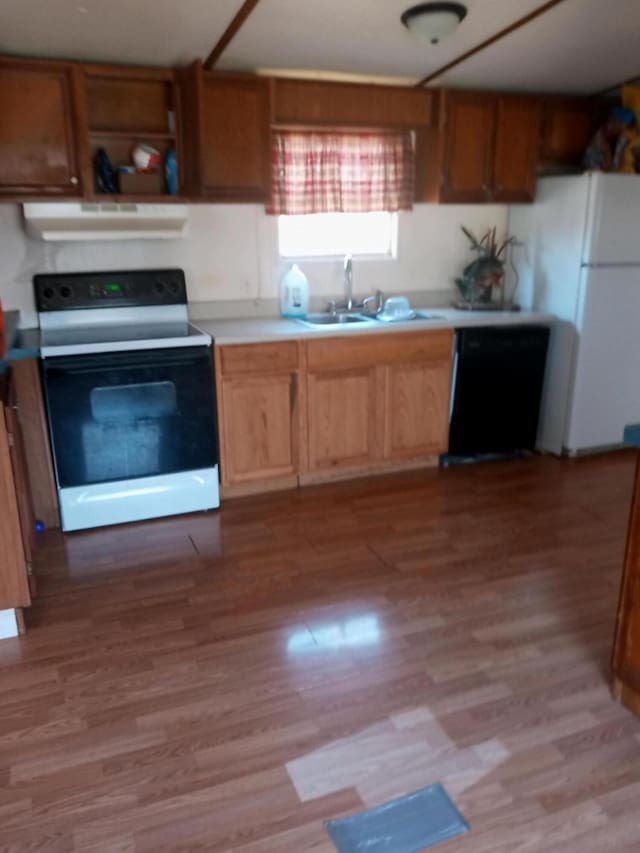 kitchen featuring electric range oven, black dishwasher, range hood, freestanding refrigerator, and a sink