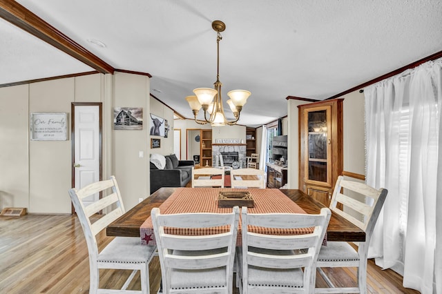 579 Fraley Rd, Salt Lick, KY 40371 - dining space featuring lofted ceiling with beams, light wood-style floors, a notable chandelier, a fireplace, and ornamental molding