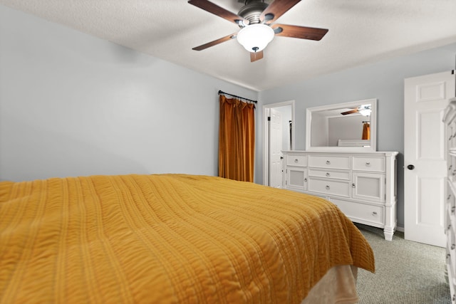 carpeted bedroom with ceiling fan and a textured ceiling