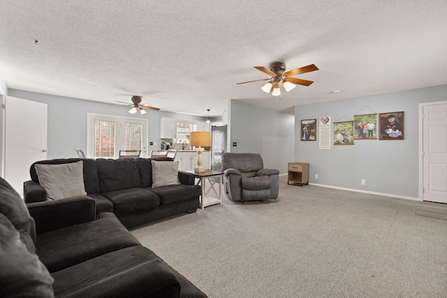 living room featuring ceiling fan, carpet, and a textured ceiling