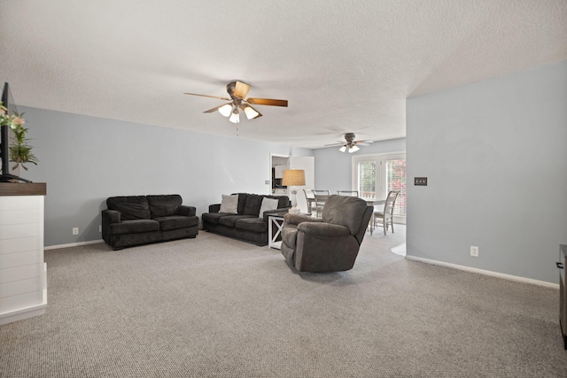 living room with ceiling fan, carpet floors, and a textured ceiling