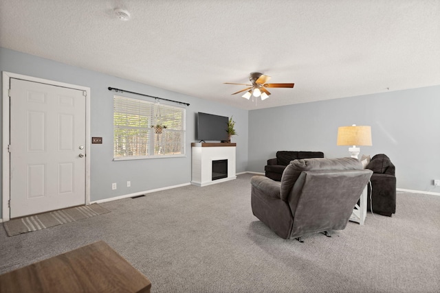 carpeted living room with ceiling fan and a textured ceiling