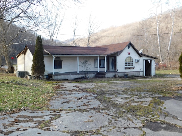 view of front of home with a porch and central AC unit