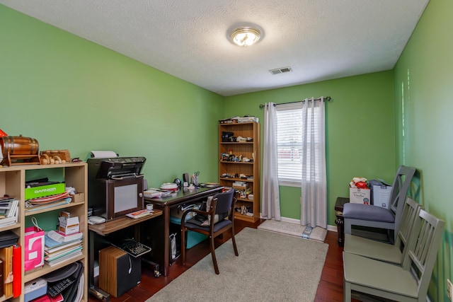 office area featuring visible vents, baseboards, a textured ceiling, and wood finished floors