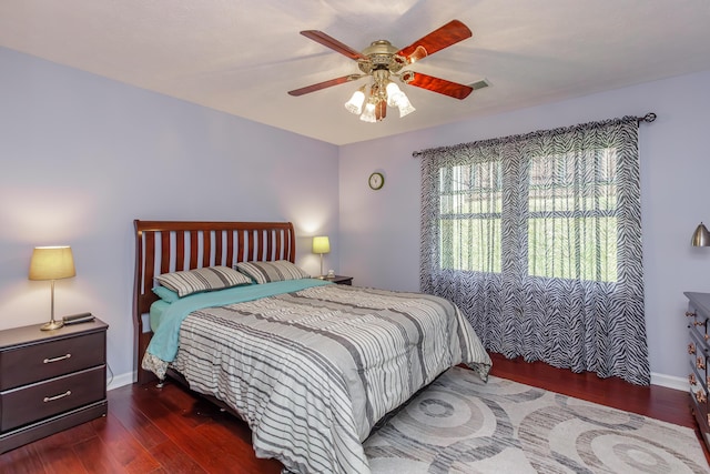 bedroom featuring visible vents, baseboards, wood finished floors, and a ceiling fan