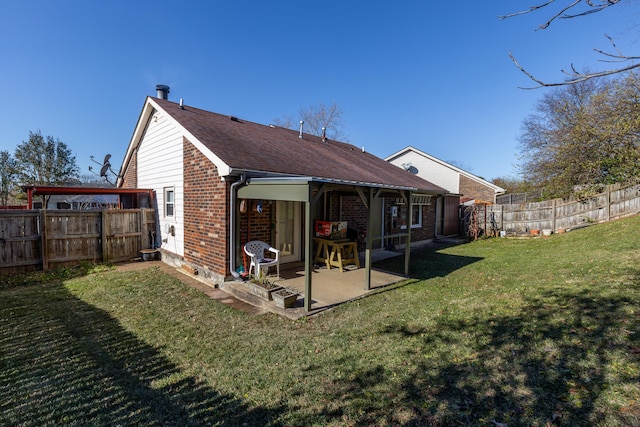 back of house featuring fence, a patio area, brick siding, and a lawn