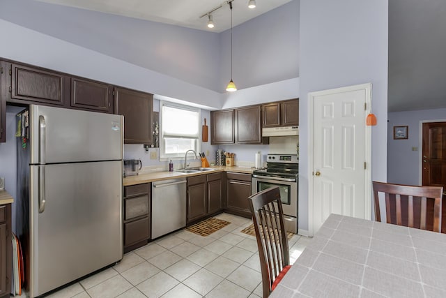 kitchen featuring a sink, under cabinet range hood, appliances with stainless steel finishes, light countertops, and dark brown cabinets