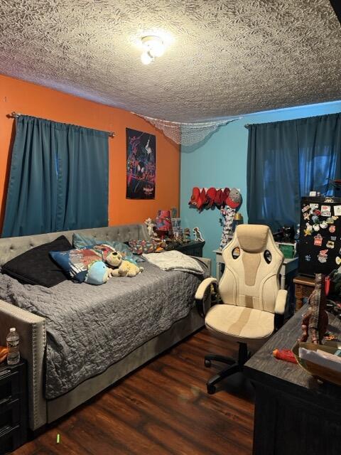 bedroom with dark hardwood / wood-style flooring and a textured ceiling