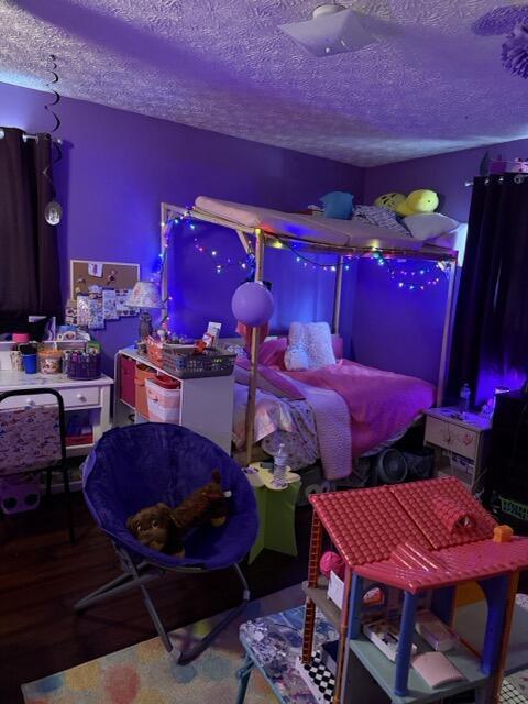 bedroom with hardwood / wood-style floors and a textured ceiling