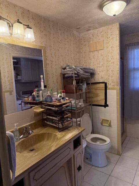 bathroom featuring tile patterned flooring, vanity, an enclosed shower, toilet, and a textured ceiling