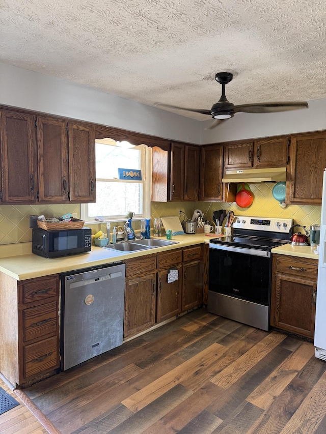 kitchen with appliances with stainless steel finishes, tasteful backsplash, sink, dark hardwood / wood-style flooring, and ceiling fan