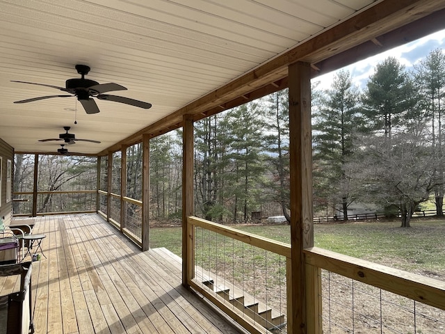 deck featuring ceiling fan and a lawn