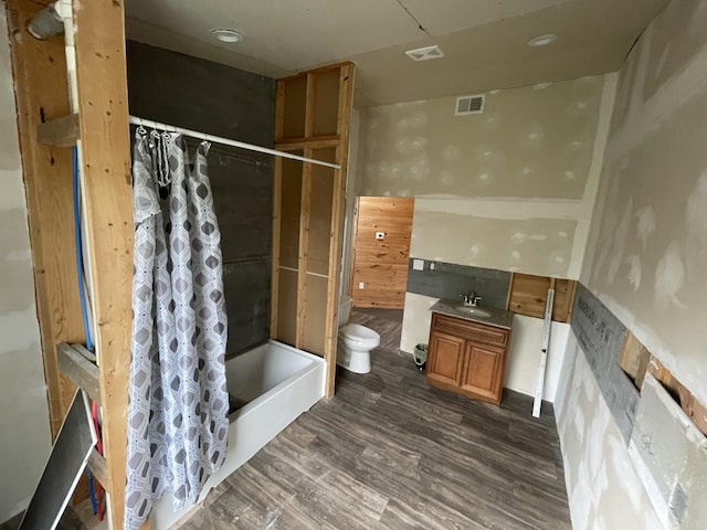 full bathroom featuring shower / tub combo with curtain, sink, wood-type flooring, and toilet