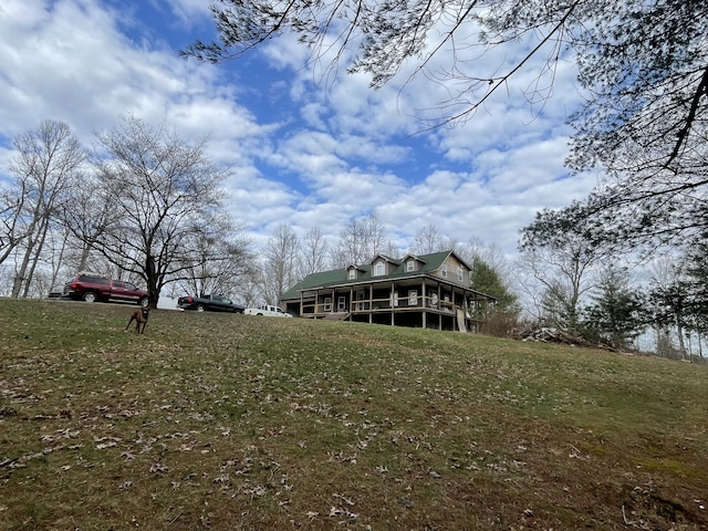 rear view of house featuring a sunroom and a lawn