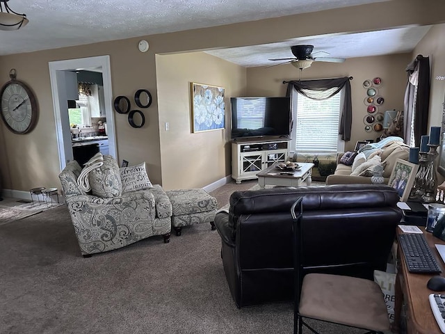 carpeted living room featuring ceiling fan, a textured ceiling, and baseboards