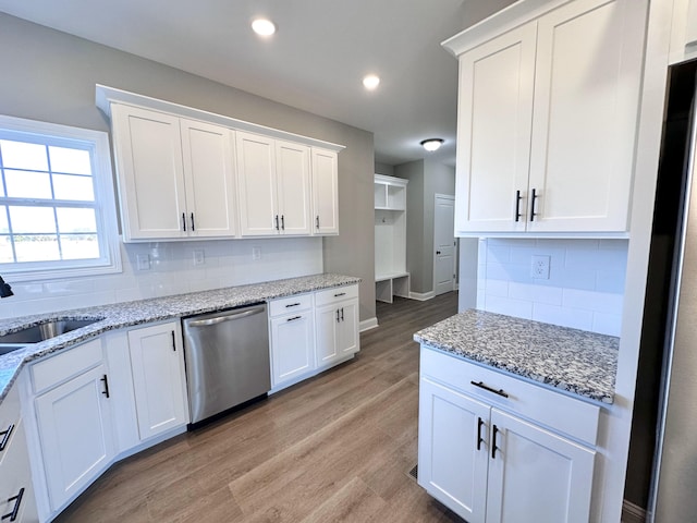 kitchen featuring dishwasher, sink, and white cabinets