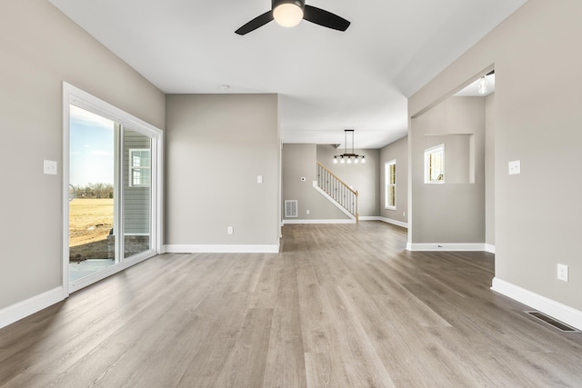 unfurnished living room with light wood-style floors, visible vents, and baseboards