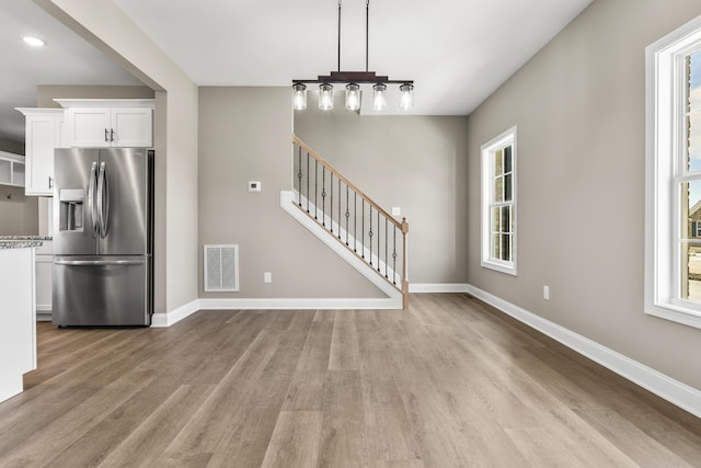 interior space with a healthy amount of sunlight, visible vents, stairway, and baseboards