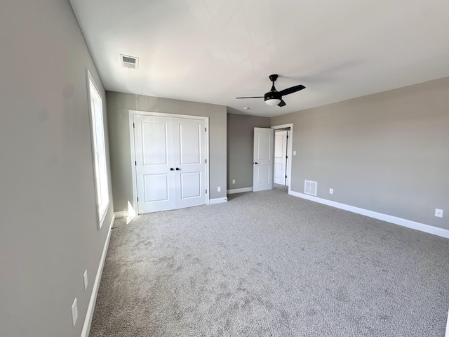 unfurnished bedroom featuring carpet floors, ceiling fan, and a closet