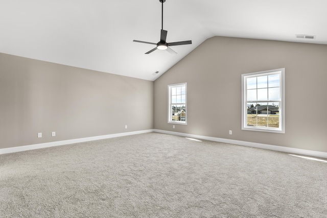 carpeted empty room featuring a ceiling fan, visible vents, vaulted ceiling, and baseboards