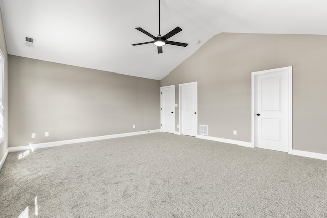 carpeted spare room with baseboards, high vaulted ceiling, visible vents, and a ceiling fan