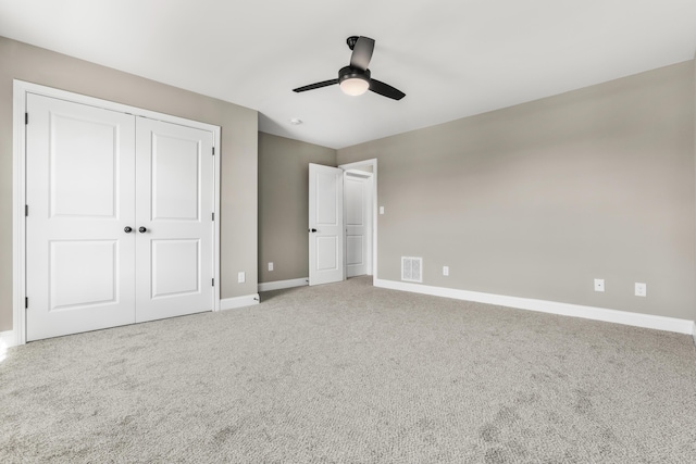 unfurnished bedroom with visible vents, baseboards, a ceiling fan, carpet, and a closet