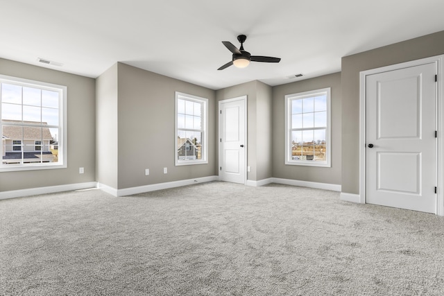 unfurnished bedroom with multiple windows, visible vents, and light colored carpet