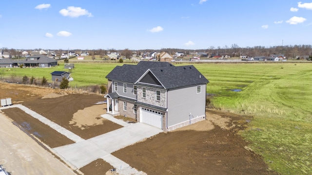 view of front of house featuring a garage, stone siding, a residential view, and driveway