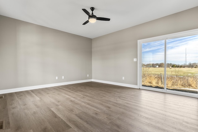 unfurnished room featuring ceiling fan, baseboards, and wood finished floors