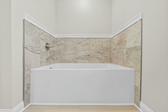 bathroom with hardwood / wood-style flooring and a washtub