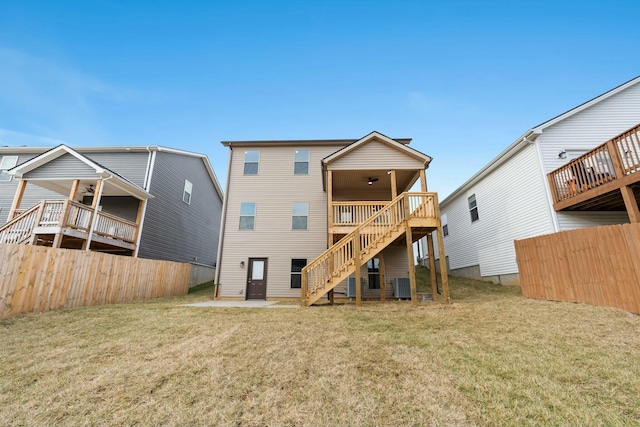 rear view of house with central AC, a patio area, and a lawn