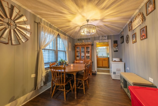 dining area featuring crown molding, dark hardwood / wood-style floors, sink, and a notable chandelier